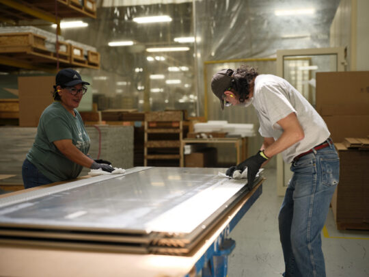 Two Shop Employees Cleaning a Composite Panel