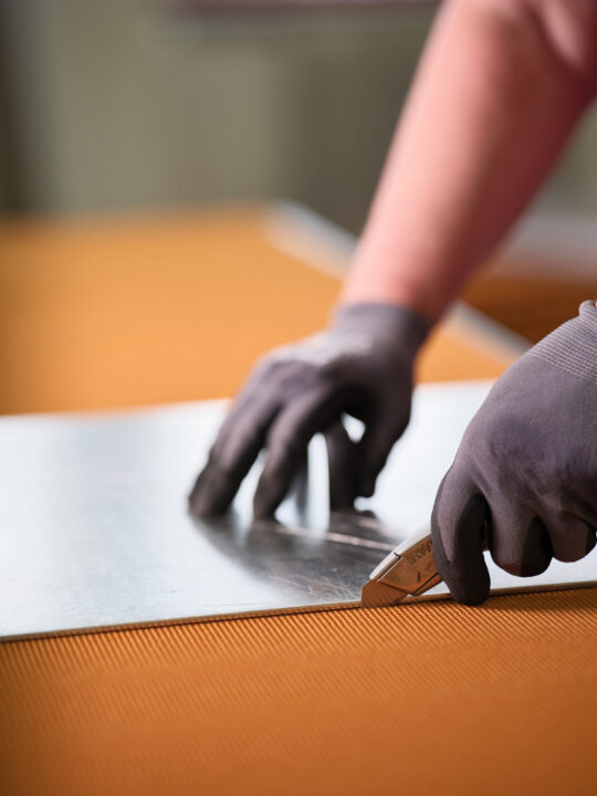 Quality control. Close up shot of employee's hands cutting a section of aramid fiber honeycomb